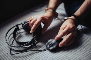 Hands resting beside headphones and a computer mouse